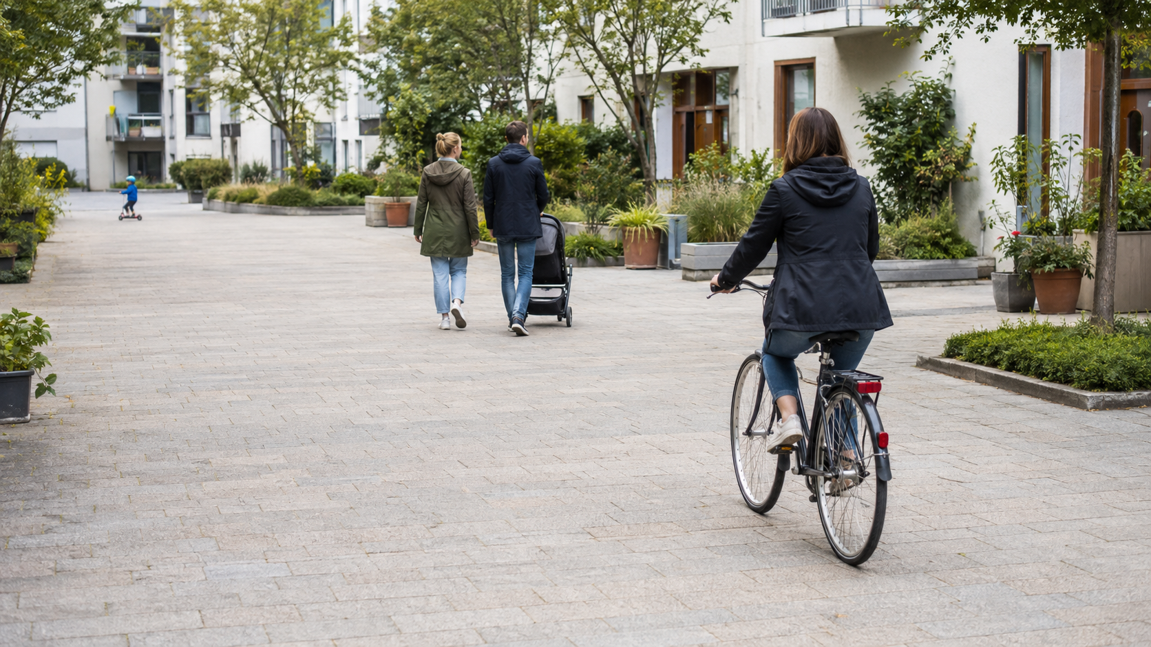 Radfahrerin fährt langsam und mit Abstand durch ein Wohnquartier