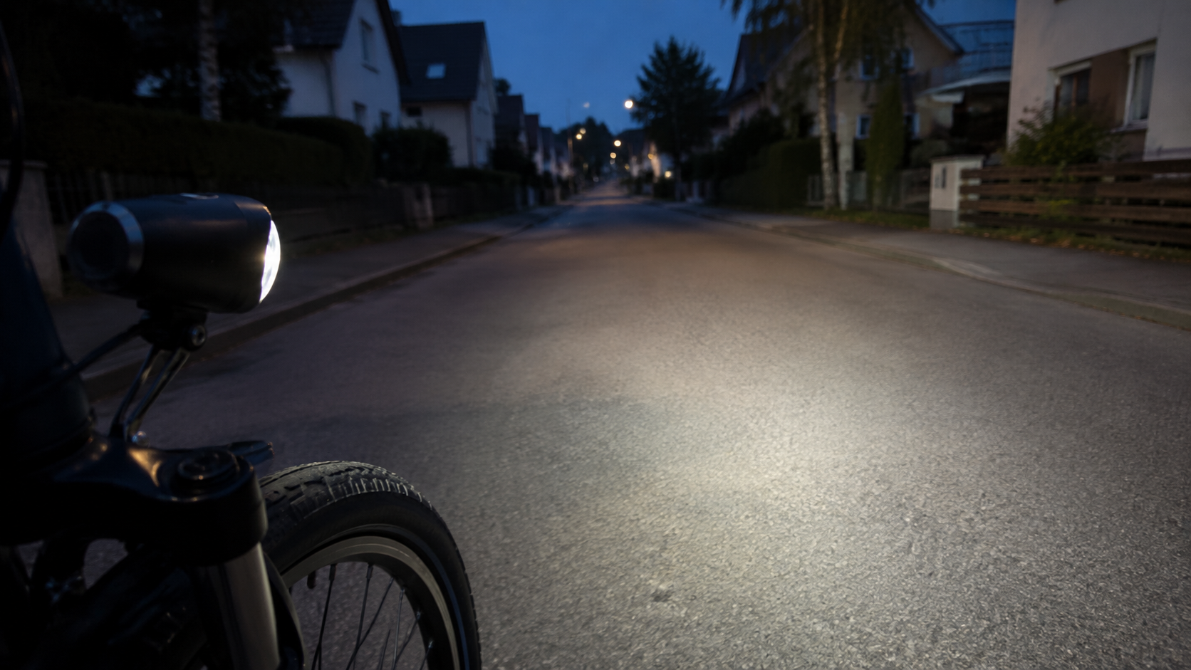 Fahrradscheinwerfer beleuchtet eine Wohnstraße bei Dämmerung